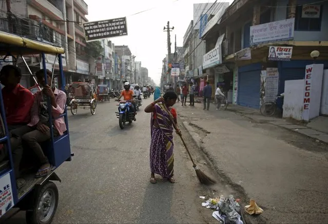 A woman sweeps the road after the curfew is lifted in Birgunj, Nepal November 5, 2015. (Photo by Navesh Chitrakar/Reuters)