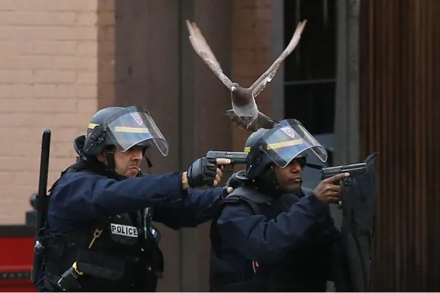 Police forces operate in Saint-Denis, a northern suburb of Paris, Wednesday, November 18, 2015. Police say two suspects in last week's Paris attacks, a man and a woman, have been killed in a police operation north of the capital. Two police officers have been injured in the standoff. Police have said the operation is targeting the suspected mastermind of last week's attacks. (Photo by Francois Mori/AP Photo)