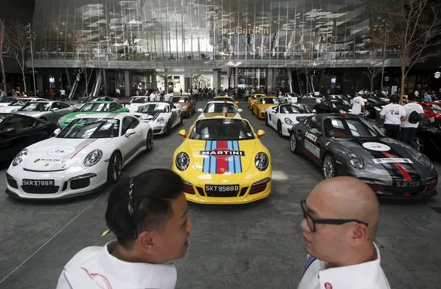 Members of the local Porsche motoring club chat during an event in Singapore's central business district July 24, 2015. (Photo by Edgar Su/Reuters)