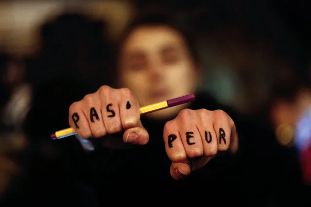 A woman holds up her hands bearing the words “Not afraid” in French during a gathering in solidarity of the victims of a terror attack against French satirical newspaper Charlie Hebdo in Paris, Wednesday, January 7, 2015. (Photo by Thibault Camus/AP Photo)
