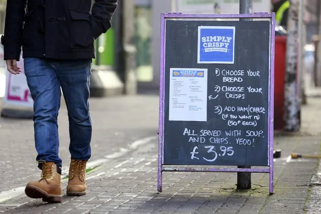 A man walks past an advertising board outside the Simply Crispy sandwich cafe in Belfast, northern Ireland January 12, 2015. (Photo by Cathal McNaughton/Reuters)