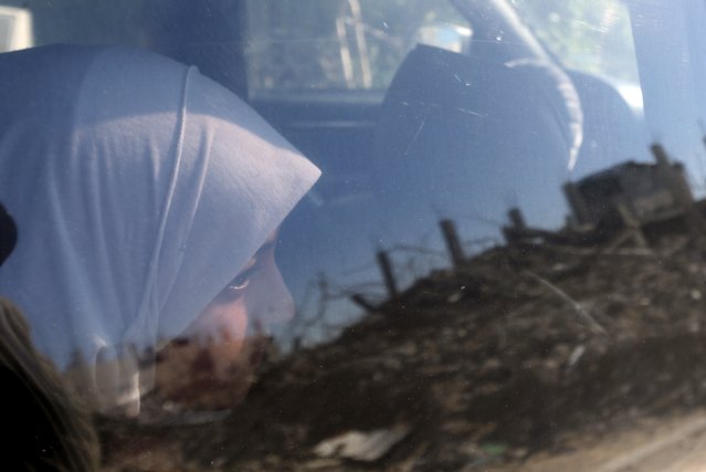 Palestinian girl Manar Al-Shinbari, 15, who lost her both legs by what medics said was Israeli shelling at a UN-run school where she was taking refuge during a 50-day war last summer, looks out a car window at the ruins of her house (reflected in the window) that witnesses said was destroyed by Israeli shelling during the war, in Biet Hanoun in the northern Gaza Strip January 13, 2015. (Photo by Mohammed Salem/Reuters)