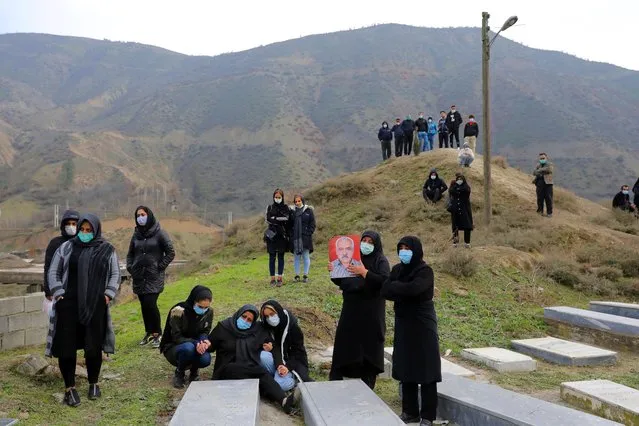 Mourners attend the funeral of a man who died from COVID-19 at a cemetery in the outskirts of the city of Ghaemshahr, in northern Iran, Wednesday, December 16, 2020. (Photo by Ebrahim Noroozi/AP Photo)
