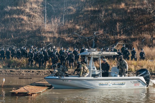 Police in a boat destroy a makeshift bridge built by protesters during a protest against the building of a pipeline near the Standing Rock Indian Reservation near Cannonball, North Dakota, U.S. November 2, 2016. (Photo by Stephanie Keith/Reuters)