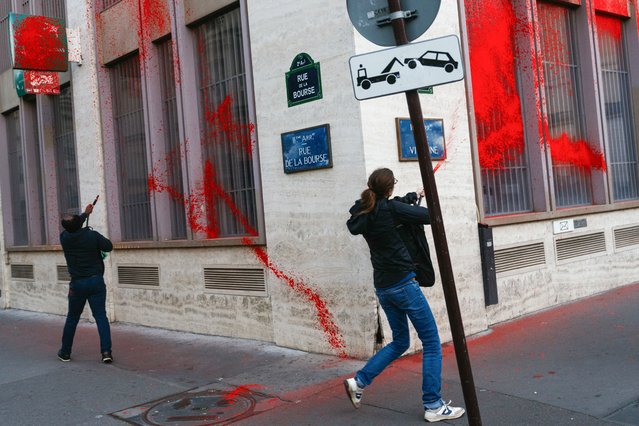 Activists from Action Justice Climat (Action Justice Climate) paint the facade of French multinational bank and financial services holding company BNP Paribas at Place de la Bourse in Paris on October 24, 2024, as they accuse BNP Paribas to finance Israeli state, through the purchase of bonds, and thereby to participate in the war in Gaza. (Photo by Dimitar Dilkoff/AFP Photo)