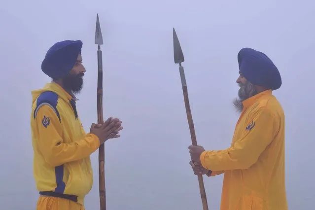 Indian Sikh sewadars – volunteers – stand during dense fog at the Golden Temple in Amritsar on December 9, 2015. (Photo by Narinder Nanu/AFP Photo)