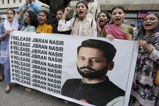 Members of a civil society group hold a banner with the picture of Pakistani human rights lawyer Jibran Nasir during a demonstration to condemn his abduction, in Karachi, Pakistan, Friday, June 2, 2023. Nasir is missing after more than a dozen armed men snatched him from his car n Thursday evening, his family said. (Photo by Fareed Khan/AP Photo)