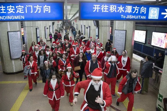 Participants dressed in Santa Claus costumes leave at a subway station to attend the SantaCon in Beijing, China, December 12, 2015. Dozens of people participated in the SantaCon in Beijing on Saturday to celebrate the upcoming Christmas. (Photo by Reuters/China Daily)