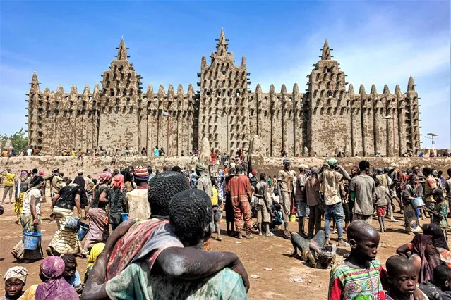 People look on at the Great Mosque of Djenne in central Mali on June 4, 2023. Thousand of people from Djenne gather each year to re-plaster the walls of the Great Mosque of Djenne, which has been build from mud since 1907. (Photo by Ousmane Makaveli/AFP Photo)