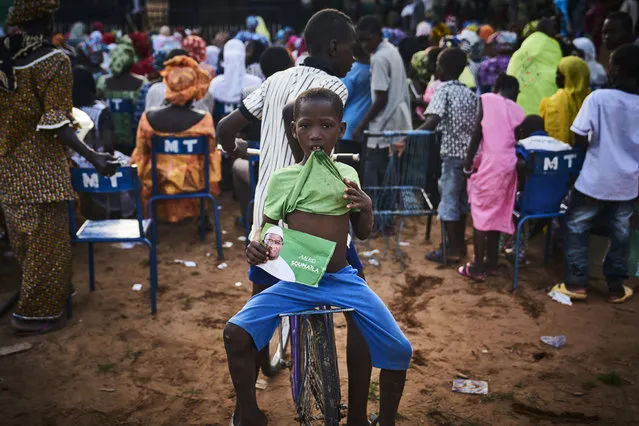 A young boy holds a flyer of Malian opposition candidate for the presidential elections Soumaila Cisse during a rally in Koulikoro on July 12, 2018. Mali's incumbent president Ibrahima Boubacar Keita, who took office in 2013, and opposition frontrunner Soumaila Cisse are expected to be the two main candidates in the July 29 polls out of a field of 24 hopefuls. (Photo by Michele Cattani/AFP Photo)