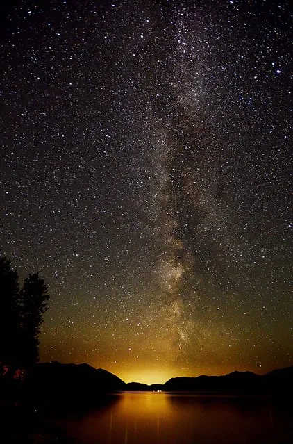 In a photo distributed today, the Milky Way lights up the sky just after 3 a.m. on July 18 over Lake McDondald in Glacier National Park, Montana. (Photo by Brenda Ahearn/Daily Inter Lake)
