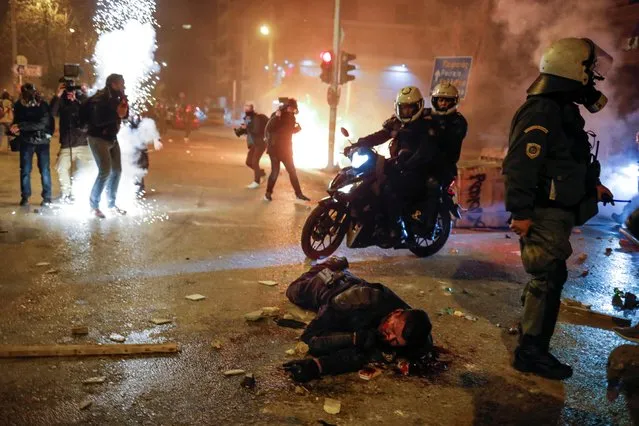 An injured police officer lies in the street during a demonstration against a police crackdown on gatherings, in Athens, Greece, March 9, 2021. Severe clashes broke out Tuesday in Athens after youths protesting an incident of police violence attacked a police station with petrol bombs, and severely injured one officer. (Photo by Alkis Konstantinidis/Reuters)