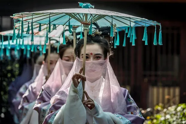 Women in traditional Chinese Hanfu attire perform an ancient costume parade to show style of Han and Tang Dynasties and to celebrate the Cherry Blossoms Festival in zen-themed Nianhuawan town, near Wuxi city, Jiangsu Province, China, 22 March 2021. Cherry blossoms in China represent love and the female mystique such as beauty, strength, and sexuality. The blooming season is mid-March to mid-April when China's numerous cities celebrate the Cherry Blossom Festivals. (Photo by Alex Plavevski/EPA/EFE)
