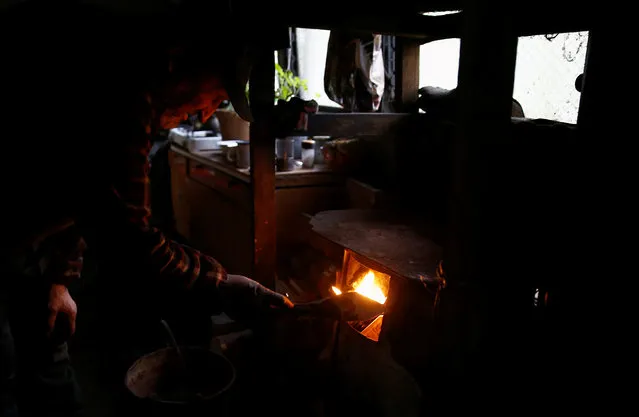 Charcoal burner Zygmunt Furdygiel fires wood stove inside his hut at a charcoal making site in the forest of Bieszczady Mountains, near Baligrod village, Poland October 27, 2016. (Photo by Kacper Pempel/Reuters)