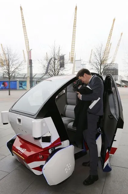 A member of the media photographs a prototype of a Lutz Pathfinder driverless vehicle is displayed to members of the media in Greenwich, east London, February 11, 2015. (Photo by Suzanne Plunkett/Reuters)