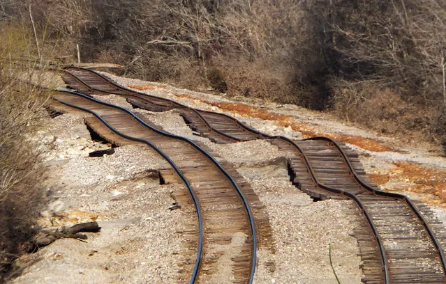 Railroad tracks, running under Interstate 44 in Eureka, Mo., near Route 66 State Park, that were undermined by floodwaters from the Meramec River and are visible on Friday, January 1, 2016. The worst of the dangerous, deadly winter flood is over in the St. Louis area, leaving residents of several water-logged communities to spend the first day of 2016 assessing damage, cleaning up and figuring out how to bounce back – or in some cases, where to live. (Photo by Jennie Crabbe/St. Louis Post-Dispatch via AP Photo)