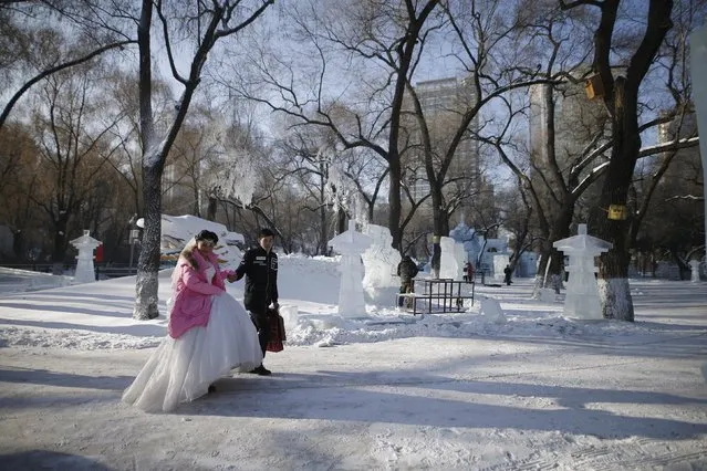 A newly-wed couple attends their group wedding ceremony which was held as part of the Harbin International Ice and Snow Festival in the northern city of Harbin, Heilongjiang province, January 6, 2016. (Photo by Aly Song/Reuters)