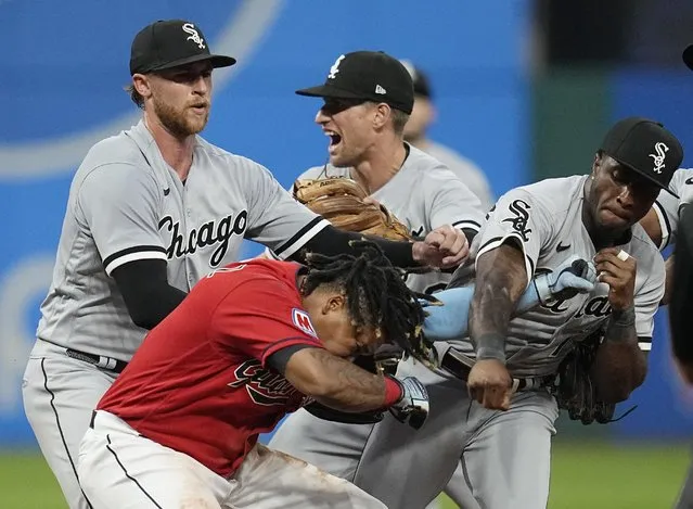 Chicago White Sox's Tim Anderson, right, punches Cleveland Guardians' Jose RamÌrez, center, in the sixth inning of a baseball game Saturday, Aug. 5, 2023, in Cleveland. White Sox pitcher Michael Kopech, left, looks on. (Photo by Sue Ogrocki/AP Photo)