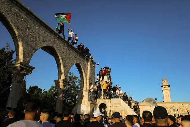 People wave Palestinian flags during Eid al-Fitr prayers, which marks the end of the holy fasting month of Ramadan, at the compound that houses al-Aqsa mosque, known to Muslims as Noble Sanctuary and to Jews as Temple Mount, in Jerusalem's Old City, amid Israel-Gaza fighting May 13, 2021. (Photo by Ammar Awad/Reuters)