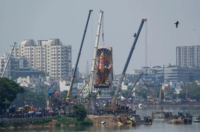 A huge clay idol of elephant-headed Hindu god Ganesha is lifted with cranes for immersion in the Hussain Sagar Lake on the final day of the ten-day long Ganesh Chaturthi festival in Hyderabad, India, Thursday, September 28, 2023. The festival is a celebration of the birth of Ganesha, the Hindu god of wisdom, prosperity and good fortune. (Photo by Mahesh Kumar A./AP Photo)