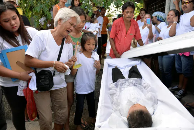 The grandmother (2-L) of 5-year-old Francisco Manosca, son of Domingo Manosca who according to relatives was a drug user, mourns over his body during his funeral in Pasay city, Metro Manila, Philippines, December 21, 2016. According to relatives and neighbours, unidentified gunmen opened fire in their home, killing both the father and child. (Photo by Ezra Acayan/Reuters)