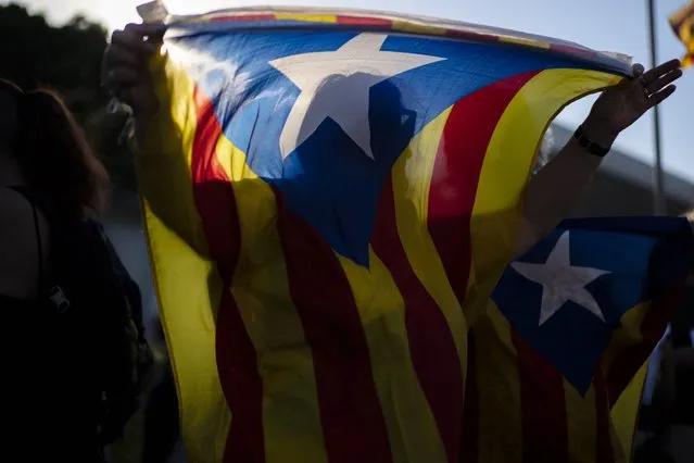 A protester holds an Estelada pro-independence flag during a protest against the visit of Spain's King Felipe VI to Barcelona, Spain, Sunday, June 27, 2021. Supporters of independence for Catalonia have protested against a visit to its regional capital Barcelona by Spain's King Felipe VI, who is a symbol of rule from Madrid. The visit came as high-level efforts to allay tensions there gain new momentum. The king is in Barcelona to help mark the opening of a major international wireless trade fair. (Photo by Joan Mateu/AP Photo)