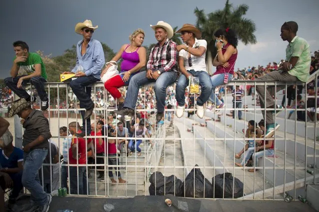 People react as they watch a rodeo show at the International Livestock Fair in Havana March 21, 2015. (Photo by Alexandre Meneghini/Reuters)