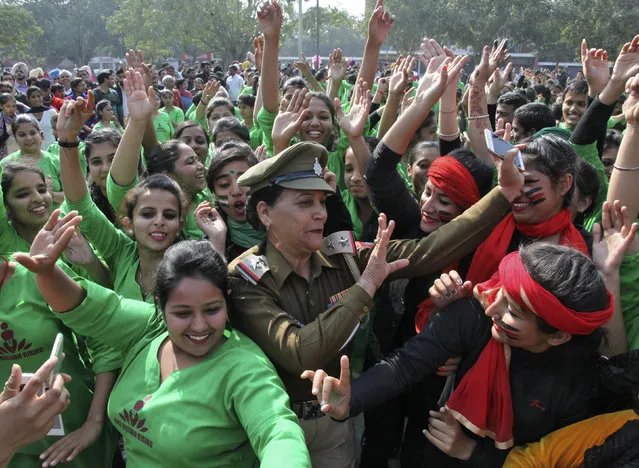 Students and a women police officer (C) dance as they take part in “One Billion Rising” campaign on a street in Chandigarh, India, February 2, 2016. One Billion Rising is a global coordinated campaign aimed to call for an end to violence against women and girls, according to its organisers. (Photo by Ajay Verma/Reuters)