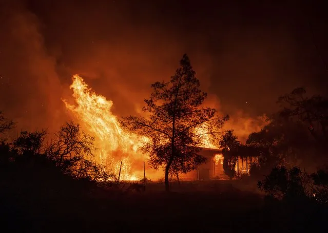 A structure is engulfed in flames as a wildfire called the Highland Fire burns in Aguanga, Calif., Monday, October 30, 2023. A wildfire fueled by gusty Santa Ana winds ripped through rural land southeast of Los Angeles on Monday, forcing thousands of people from their homes, fire authorities said. (Photo by Ethan Swope/AP Photo)