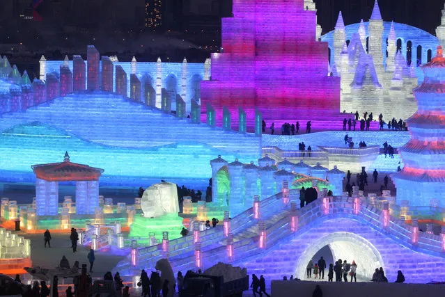 People visit illuminated ice sculptures at the Ice and Snow World park ahead of the Harbin International Ice and Snow Sculpture Festival, in Harbin, Heilongjiang province, China on December 23, 2018. (Photo by Reuters/China Stringer Network)