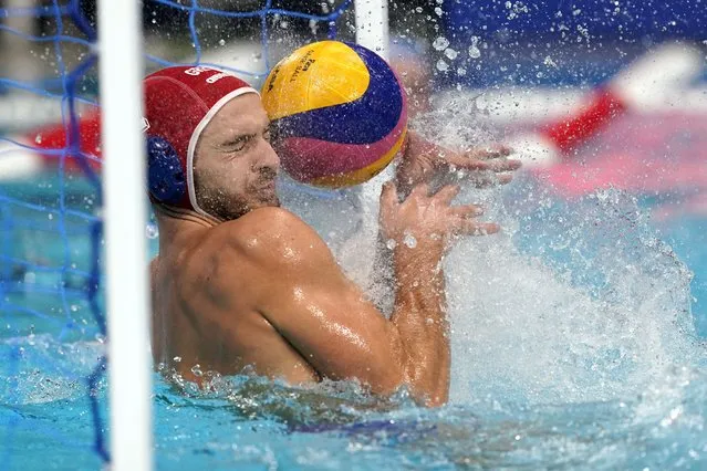 Greece goalkeeper Emmanouil Zerdevas gets hit by a shot that bounced off him for a goal during a preliminary round men's water polo match against Italy at the 2020 Summer Olympics, Tuesday, July 27, 2021, in Tokyo, Japan. (Photo by Mark Humphrey/AP Photo)