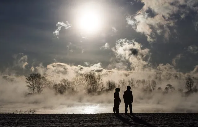 Mist rises as people look out on Lake Ontario during extreme cold weather in Toronto on Saturday, February 13, 2016. Environment Canada has issued extreme cold warnings for provinces from Manitoba to New Brunswick. (Photo by Mark Blinch/The Canadian Press via AP Photo)