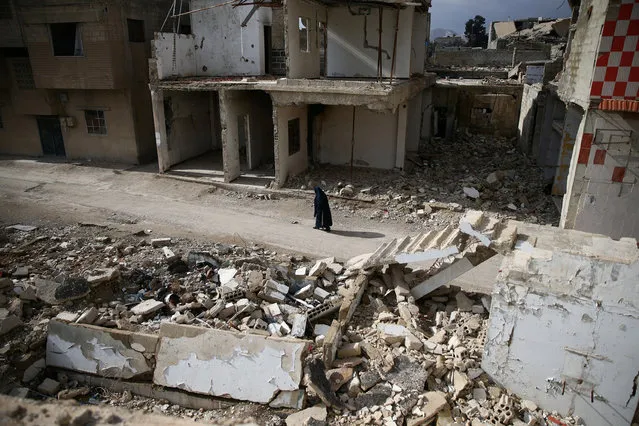A woman walks past damaged buildings in the rebel held besieged city of Douma, in the eastern Damascus suburb of Ghouta, Syria January 8, 2017. (Photo by Bassam Khabieh/Reuters)
