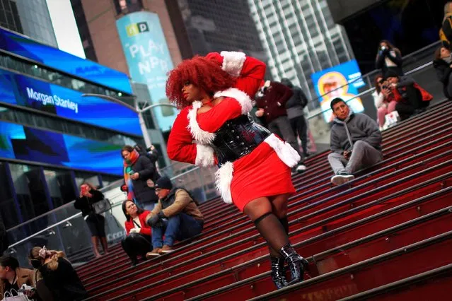 A woman in a Christmas themed outfit poses on steps in Times Square in Manhattan in New York City on December 5, 2023. (Photo by Mike Segar/Reuters)