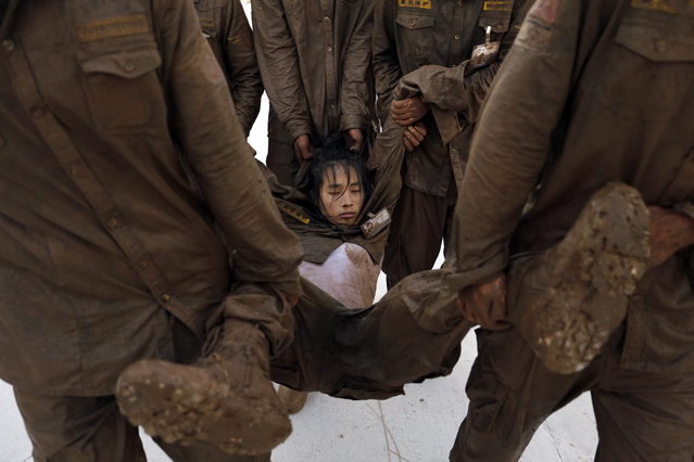 Students carry a female trainee who has fallen into a stupor during high intensity training at Tianjiao Special Guard/Security Consultant camp on the outskirts of Beijing December 1, 2013. (Photo by Jason Lee/Reuters)