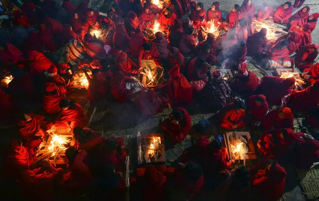 Nepali Hindu women warm themselves beside fires before taking a bath in the holy Shali River on the outskirts of Kathmandu on January 21, 2019, as Hindu devotees across the country marked the Swasthani Brata Katha festival. Hundreds of married and unmarried women in the Himalayan nation have started a month-long fast for Swasthani Brata Katha festival often marked with an auspicious bathing in water bodies in the hope of a prosperous life and conjugal happiness. (Photo by Prakash Mathema/AFP Photo)