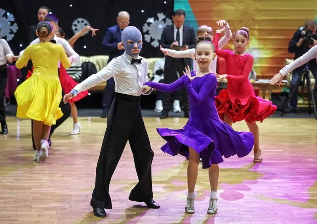 Roman, 8, wounded by Russian missile strike on the central Ukrainian city of Vinnytsia last year, performs at a ballroom dance competition, with his face covered by a burn mask, after a year of skin grafts and over 30 surgeries, in Lviv, Ukraine on December 2, 2023. (Photo by Roman Baluk/Reuters)