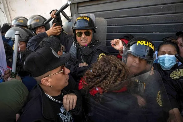 People opposing the government of Peruvian President Pedro Castillo face the police during a demonstration to demand his resignation in Lima, on November 5, 2022. Shouting “Castillo out!”, thousands of protesters marched through the streets of Lima this Saturday to demand the resignation of leftist president Pedro Castillo, who is under an unprecedented six investigations for alleged corruption. (Photo by Ernesto Benavides/AFP Photo)