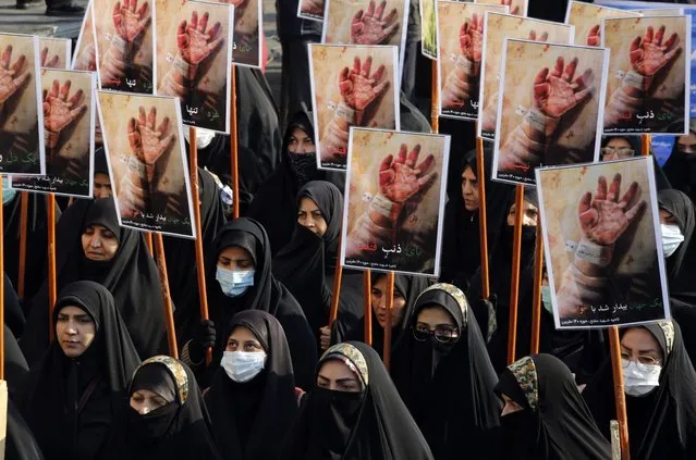 Iranian women hold placards during a march by members of Iranian premilitary forces (Basij) to show their solidarity with Gaza people, in Tehran, Iran, 24 November 2023. Thousands of Israelis and Palestinians have died since the militant group Hamas launched an unprecedented attack on Israel from the Gaza Strip on 07 October, and the Israeli strikes on the Palestinian enclave which followed it. (Photo by Abedin Taherkenareh/EPA/EFE)