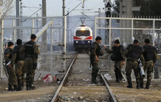 Macedonian police open a gate on the Macedonian-Greek border for a cargo train to pass near Gevgelija, Macedonia March 8, 2016. (Photo by Ognen Teofilovski/Reuters)