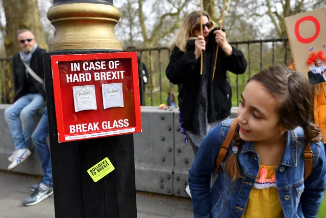 A participant looks at a box “In case of hard Brexit break glass” containing bags of tea displayed during the “People's Vote” march in central London, Britain on March 23, 2019. (Photo by Dylan Martinez/Reuters)