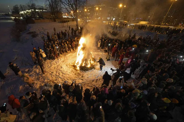 Believers gather around a ritual bonfire during the Dugzhuuba, a Buddhist pre-New Year ritual of purification, near the Datsan Gunzechoinei Buddhist Temple in St. Petersburg, Russia, Thursday, February 8, 2024. During the Dugzhuba ritual believers symbolically purify by eliminating all negative and harmful energies. This ritual takes place on the eve of the Buddhist New Year, called by Russian Buddhists as Sagaalgan, and follows the lunar calendar. (Photo by Dmitri Lovetsky/AP Photo)
