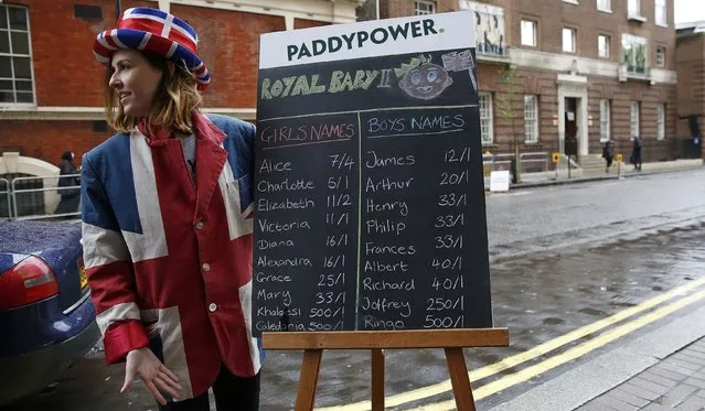A woman poses next to a betting board showing the odds of baby names outside the Lindo wing of St Mary's Hospital where Britain's Catherine, Duchess of Cambridge, is expected to give birth to her second child in the next few days, in London, Britain April 29, 2015. (Photo by Suzanne Plunkett/Reuters)