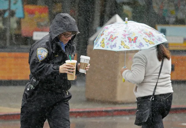 Two women take cover from the rain while crossing a street Thursday, March 10, 2016, in Sausalito, Calif. (Photo by Eric Risberg/AP Photo)