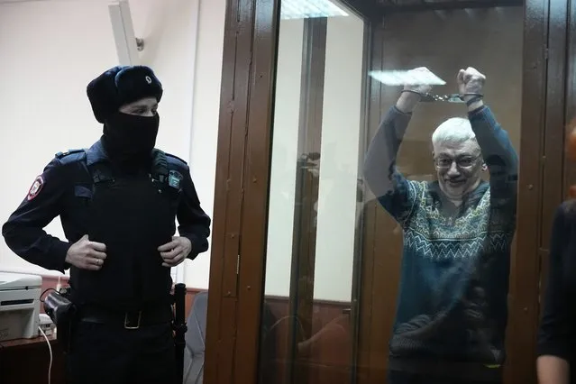 The co-chair of the Nobel Peace Prize winning Memorial Human Rights Centre Oleg Orlov gestures standing in a glass cage after he was taken into custody in the courtroom during court session for a new trial on charges of repeated discrediting Russian military, in Moscow, Russia, on Tuesday, February 27, 2024. (Photo by Alexander Zemlianichenko/AP Photo)