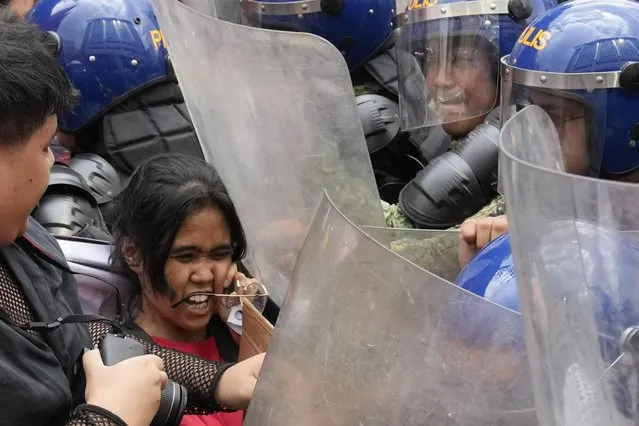 Police pushes a woman activist as they tried to march near the Malacanang presidential palace during an International Women's Day protest in Manila, Philippines on Friday, March 8, 2024. (Photo by Aaron Favila/AP Photo)