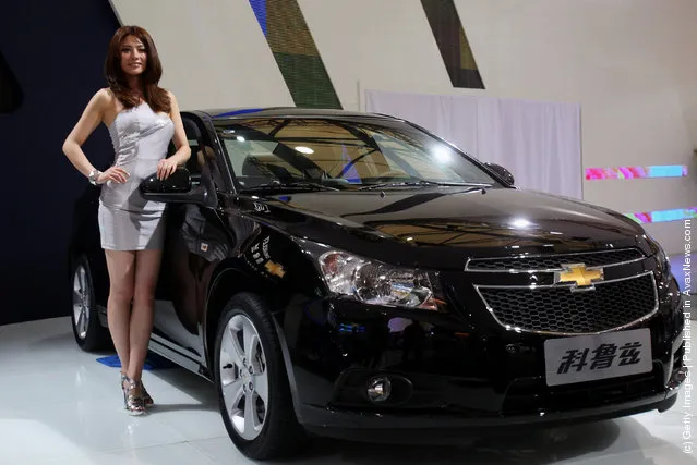 A model stands beside the Asia premiere display of Chevrolet Cruze