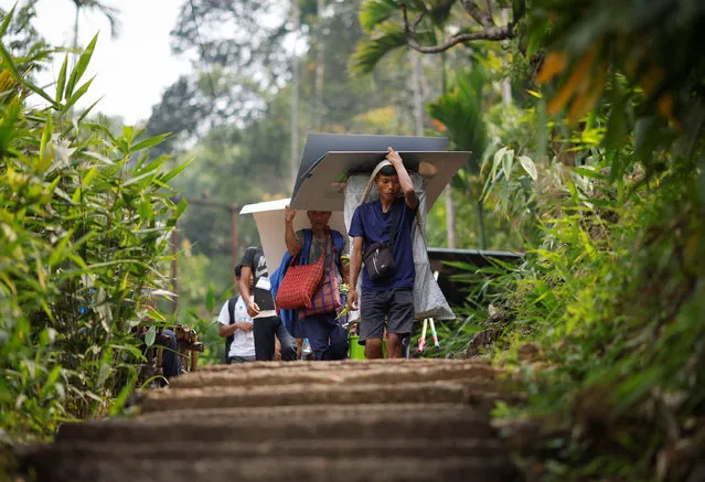Porter Wilfred Syjemlieh, 24, carries Voter Verifiable Paper Audit Trail (VVPAT) and Electronic Voting Machines (EVM) during a trek to reach a remote polling station, ahead of the first phase of the election, in Shillong in the northeastern state of Meghalaya, India, on April 17, 2024. (Photo by Adnan Abidi/Reuters)