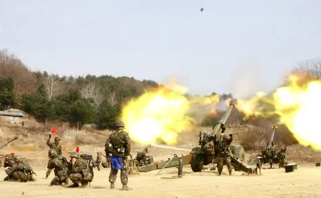 Towed 155mm Howitzers fire during an artillery drill in Inje, near the demilitarized zone (DMZ) which separates the two Koreas, in this picture provided by South Korean Army and released by Yonhap on March 27, 2014. South Korea's military on Thursday seized a North Korean fishing boat that it said had crossed a disputed maritime border after ignoring warnings to retreat amid growing tension between the two sides. (Photo by Reuters/South Korean Army/Yonhap)