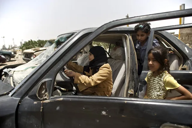 Yemeni girls play with a vehicle damaged by Saudi-led coalition airstrikes in Sanaa, Yemen, Monday, May 18, 2015. (Photo by Hani Mohammed/AP Photo)